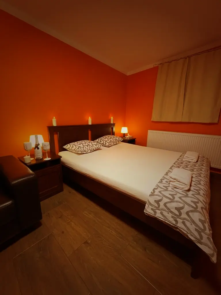 Izba s oranžovými stenami a sviečkami pri posteli